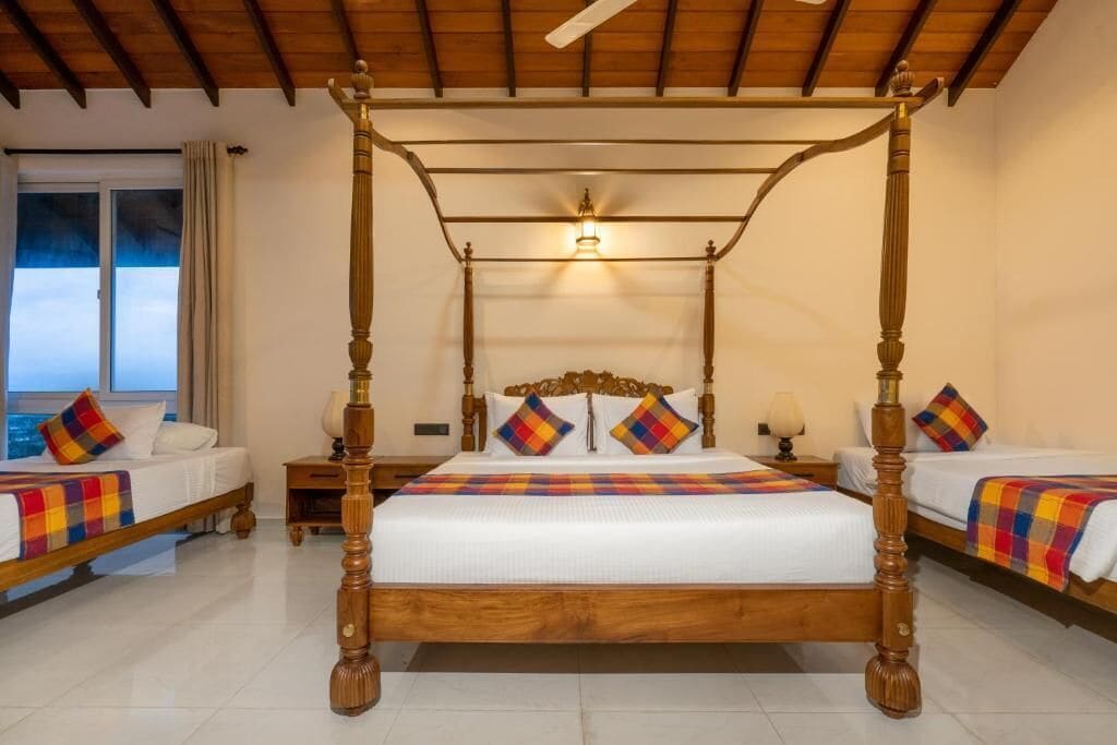 A four-poster bed with a wooden frame, two bedside tables with lamps, and a window with curtains.