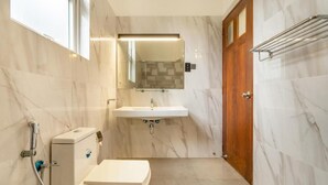 A bathroom with a toilet, sink, and shower.