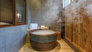 A traditional Japanese onsen with a large wooden tub, tiled walls, and a wooden floor. - Deefly Origin House Wuyi (Jinhua)