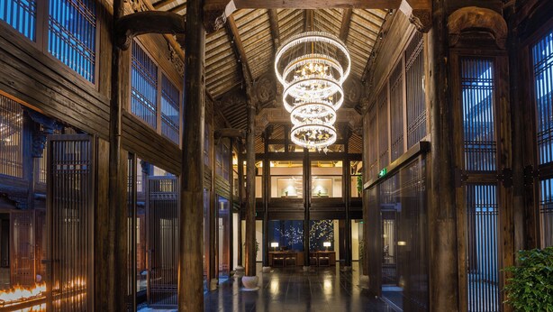 A corridor with wooden columns, a chandelier, and traditional windows. - Deefly Origin House Wuyi (Jinhua)