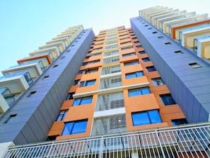 A high-rise building with multiple balconies and a modern architectural design.