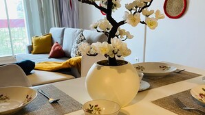 Ein Esstisch ist gedeckt mit Tellern, einer Tasse und einer Blumenvase.