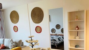 Ein Essbereich mit Tisch für vier Personen, Stühlen, einer Blumenvase und einem Bücherregal im Hintergrund.