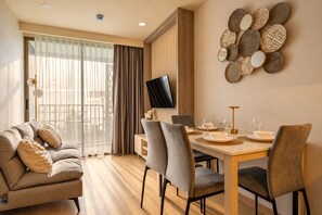 Une chambre d’hôtel moderne dotée d’un coin repas, d’un canapé et d’une télévision.