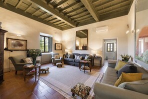 A cozy living room with a fireplace, comfortable seating, and a large mirror. - Villa Molamezza by MMega (Mercatale in Val di Pesa)