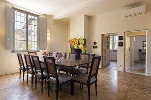 A dining room with a large table, six chairs, and a vase of flowers. - Villa Molamezza by MMega (Mercatale in Val di Pesa)
