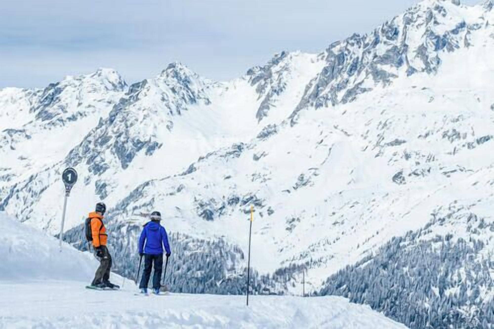 A snowy mountain landscape with skiers.