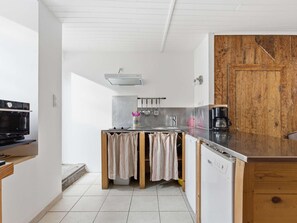 A compact kitchen with a dishwasher, a stove, and a coffee maker. - Charming house, pets welcome - 5 guests (Arreau)