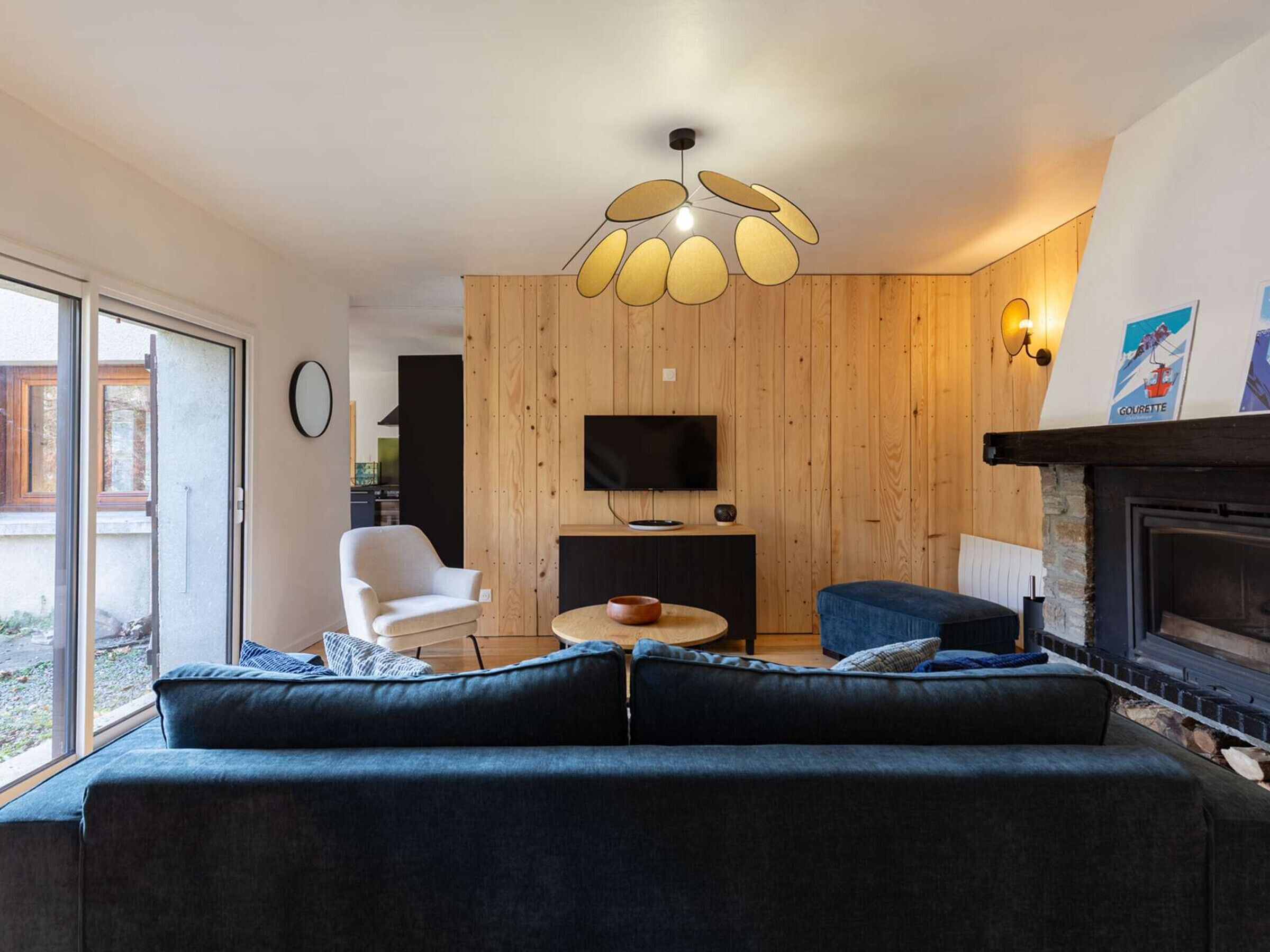 Una sala de estar moderna con un sofá, un sillón y una mesa de centro redonda.