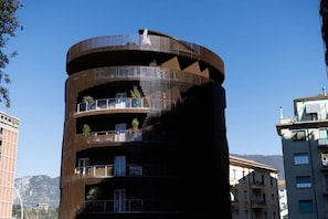 A multi-story building with balconies, a spiral design, and a clear sky in the background. - ZENIT APPARTAMENTI & SPA (Terni)