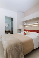 Un dormitorio con una cama, una mesita de noche, un espejo y un armario.