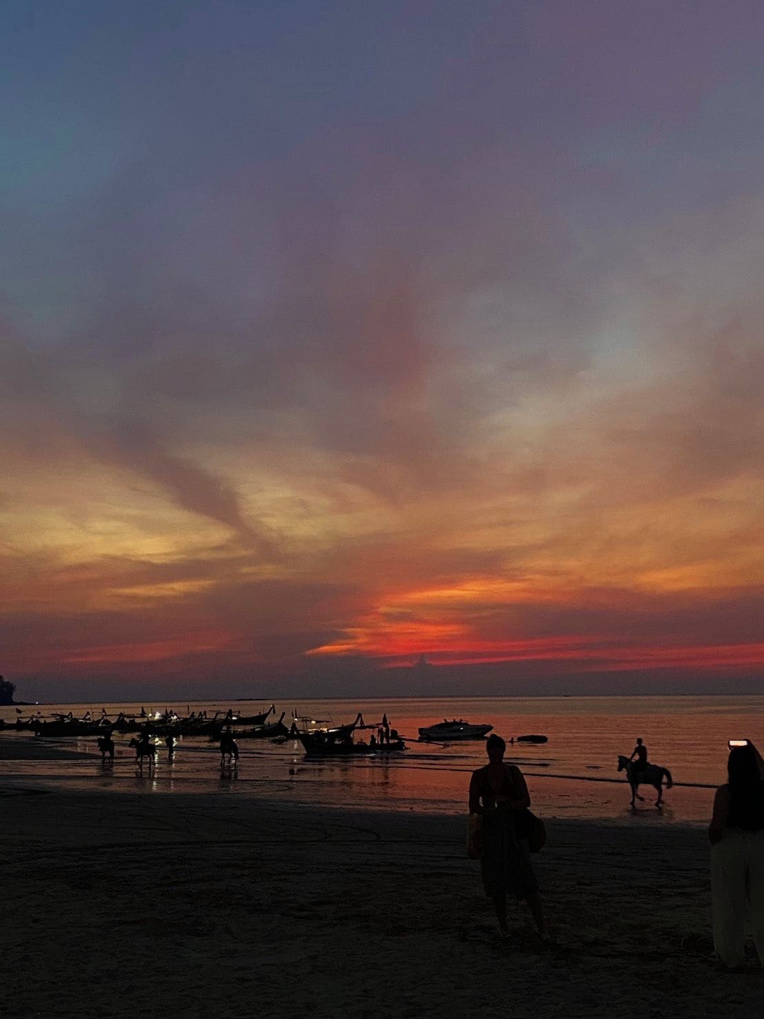 Uma praia com barcos e pessoas.