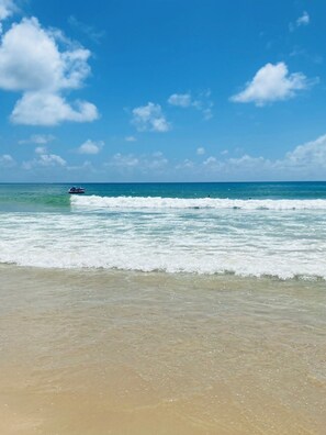 A beach with clear skies and waves.