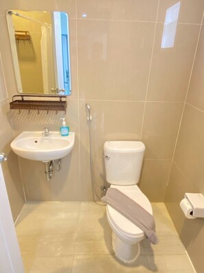 Un baño con un lavamanos blanco, un inodoro y una ducha.