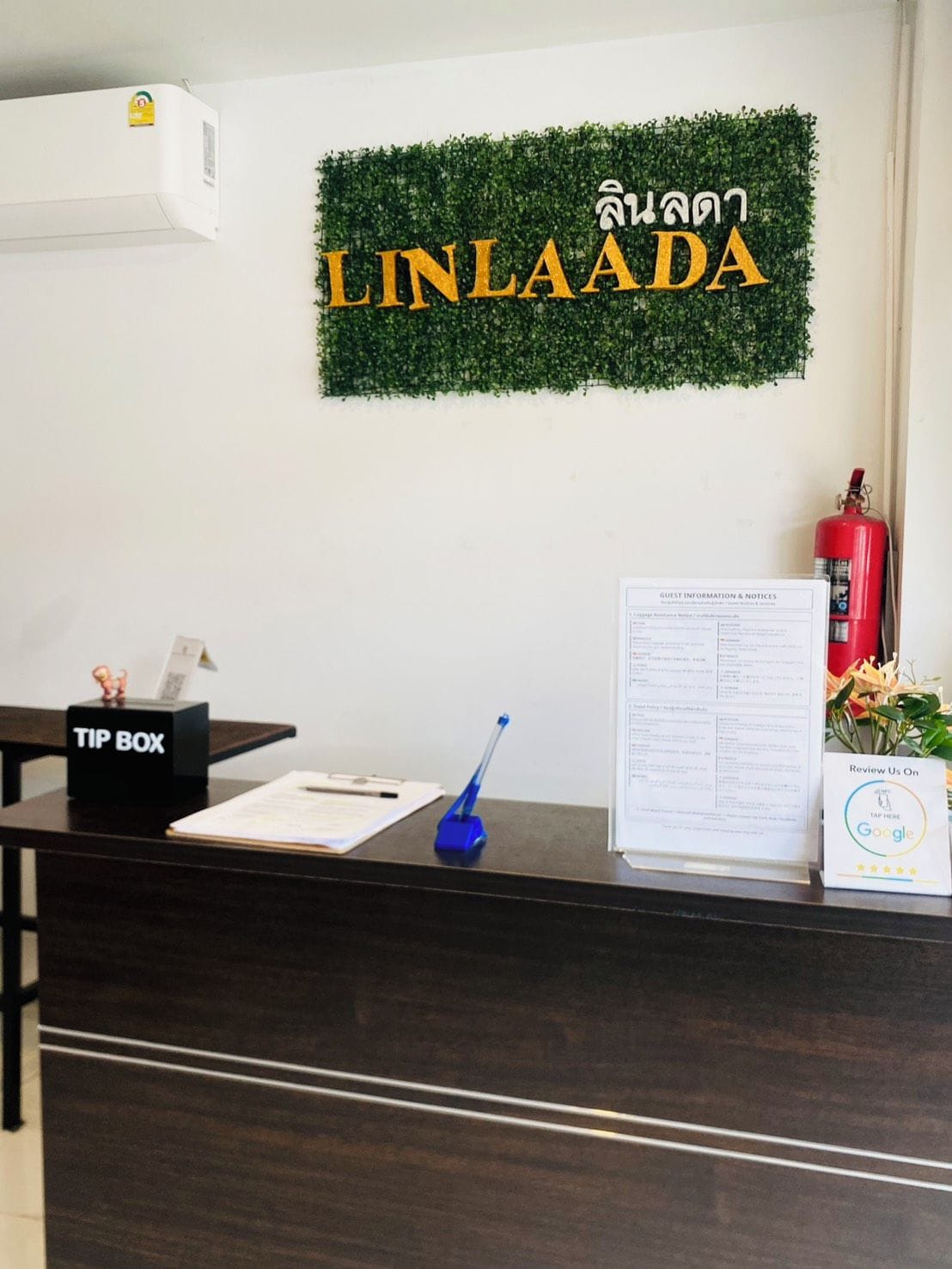 A reception desk with a 'TIP BOX' and a 'GUEST INFORMATION & NOTICES' sign.