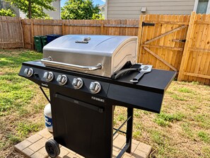 Ein Char-Broil Gasgrill mit vier Brennern, einer Seitablagefläche und einem Deckel.