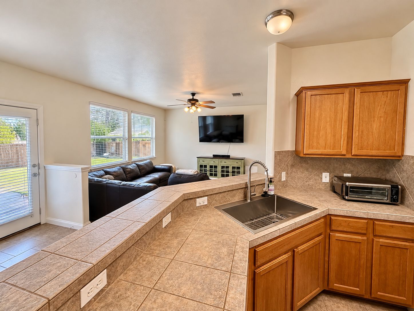 A kitchen with a built-in oven, a sink, and wooden cabinets.