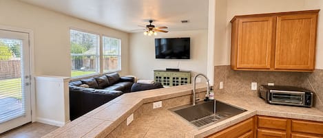 A kitchen with a built-in oven, a sink, and wooden cabinets.