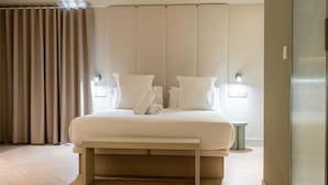 Ein modernes Hotelzimmer mit einem großen Bett, einem Nachttisch und einem Kopfteil mit integrierter Beleuchtung.