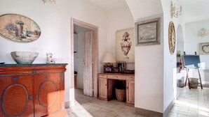 Una stanza con un armadio in legno, un quadro, uno specchio e un cesto in vimini.
