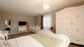 Un dormitorio con cama, cómoda, televisor, espejo y armario.