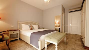 Un dormitorio con cama, mesitas de noche, un banco, un espejo y un armario.