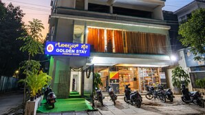 Un hotel de varios pisos con un letrero que indica 'Habitaciones' y 'Habitaciones Premium Golden Stay'.