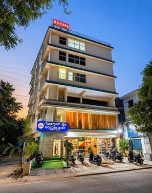 A multi-story hotel with a sign for 'Rooms' and a storefront named 'Golden Stay Premium Rooms'. - Hotel Golden Stay (Bengaluru)