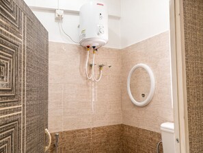 Un baño con ducha, inodoro y secador de manos.