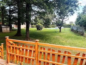 A wooden fence, a grassy lawn, and trees in a park setting.