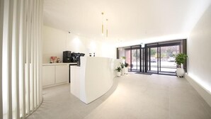 Una cocina moderna con una isla central, muebles blancos y un amplio ventanal que proporciona luz natural.