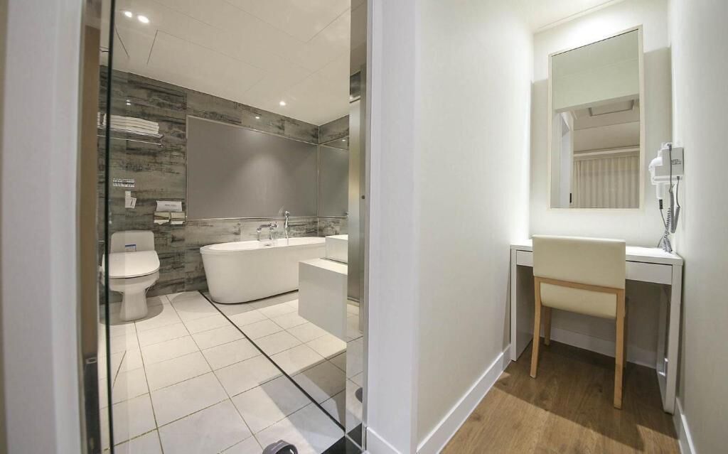 Un baño moderno con inodoro, bañera y tocador.