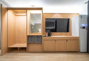 Una habitación compacta con armario empotrado, una kitchenette pequeña con cafetera y refrigerador.