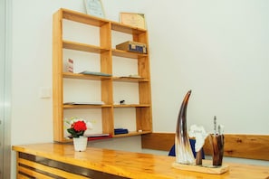 A wooden reception desk with a vase of flowers, a certificate, and a decorative horn.