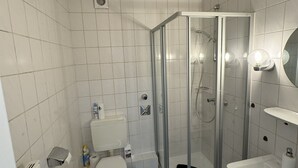 Een douche, handdoeken, toiletpapier