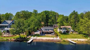 A lakeside property with a dock, a central house, and two additional buildings. - Heron's Rest – Lakefront Home w/ Hot Tub, Kayaks & Game Room (Pocono Lake)