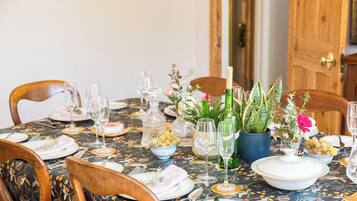 A dining table set with plates, glasses, and a centerpiece with flowers and a candle.