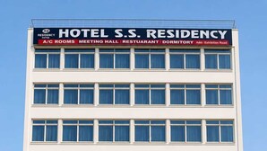 Un edificio de varios pisos con un cartel que indica que es un hotel, salón de eventos, restaurante y residencia estudiantil.
