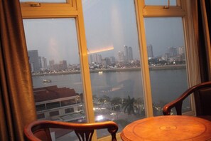Una habitación con un ventanal grande que da a una vista de la ciudad y un cuerpo de agua.