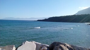 A coastal landscape with a clear sky, calm sea, and rocky shoreline. - Martineriu House (Orosei)