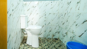 Ein Badezimmer mit Toilette, einem blauen Waschbecken und Fliesen mit Muster.