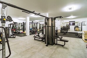 A gym with various exercise equipment, mirrors, and a clean, organized layout. - RDR563 - PH with Private Rooftop &  Sea Views (Benahavís)