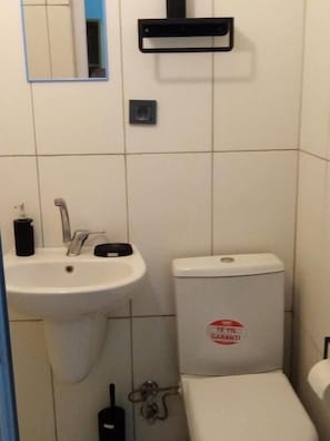 Ein Badezimmer mit Waschbecken, Toilette und Spiegel.