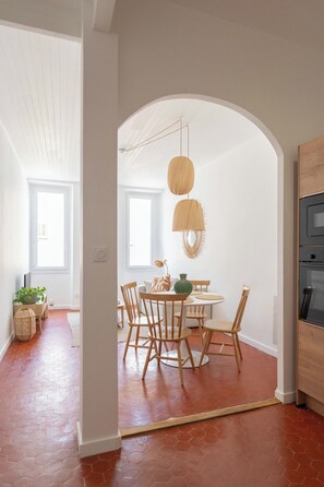 A dining area with a round table, chairs, and hanging pendant lights. - Beautiful, bright, and quiet one-bedroom apartment in the heart of the city, near the Old Port (La Ciotat)