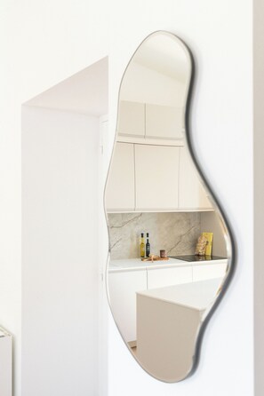 A kitchen with white cabinets, a marble countertop, and a mirror with a wavy frame. - ★ COMFORTABLE ★ BEACHFRONT ★ AIR CONDITIONING ★ HIGH-SPEED WIFI ★ PARKING INCLUDED (La Ciotat)