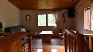 A room with a wooden ceiling, a table, a sofa, and a window with curtains. - Country cottage (Millau)