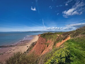 Eine Küstenlandschaft mit Strand, Klippen und blauem Himmel.