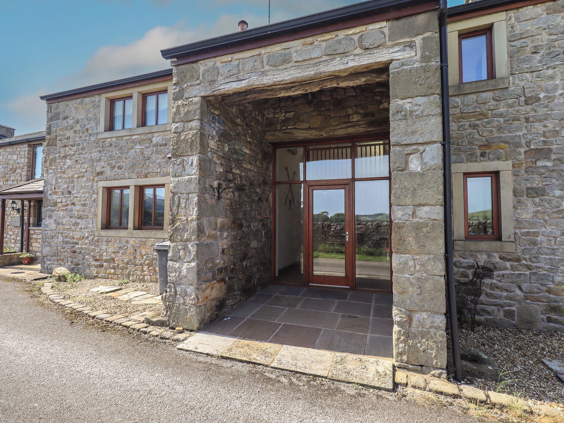 A stone building with a large entrance, multiple windows, and a view of the landscape.