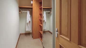 Un armario vestidor con estantes de madera y espacio para colgar ropa.