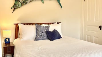 The Library Room's queen bed under a hand painted sailfish — one of four bedrooms on this floor